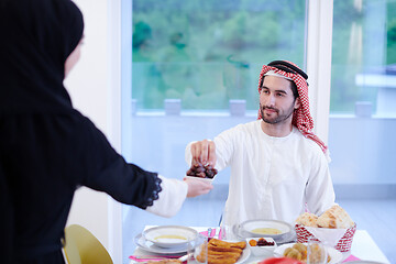 Image showing Muslim family having Iftar dinner eating dates to break feast