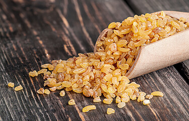 Image showing Bulgur in wooden scoop closeup 