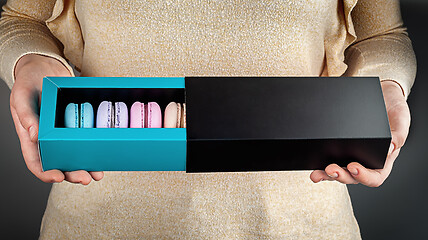 Image showing Girl holding open box with macaroons