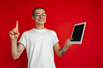 Image showing Caucasian young man\'s portrait on red studio background with copyspace - emotional and expressive