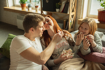 Image showing Family spending nice time together at home, looks happy and cheerful, watching TV