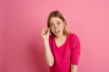 Image showing Caucasian young woman\'s monochrome portrait on pink studio background, emotinal and beautiful