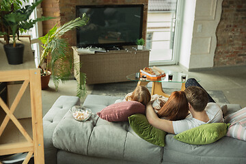 Image showing Family spending nice time together at home, looks happy and cheerful, watching TV