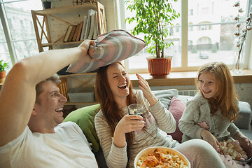 Image showing Family spending nice time together at home, looks happy and cheerful, watching TV