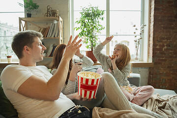 Image showing Family spending nice time together at home, looks happy and cheerful, watching TV