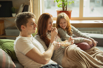 Image showing Family spending nice time together at home, looks happy and cheerful, watching TV