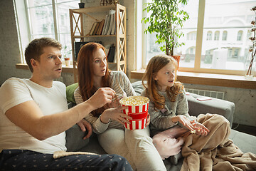 Image showing Family spending nice time together at home, looks happy and cheerful, watching TV