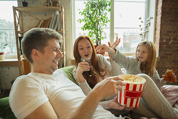 Image showing Family spending nice time together at home, looks happy and cheerful, watching TV