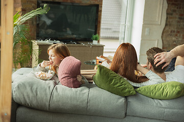 Image showing Family spending nice time together at home, looks happy and cheerful, watching TV