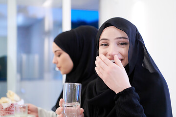 Image showing Muslim family having Iftar dinner drinking water to break feast