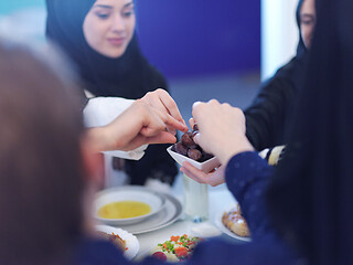 Image showing Muslim family having Iftar dinner eating dates to break feast