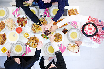 Image showing Muslim family having Iftar dinner eating dates to break feast to