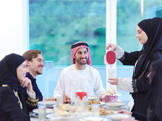 Image showing Muslim family having Iftar dinner drinking water to break feast