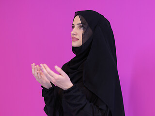 Image showing muslim woman making traditional prayer to God isolated on pink