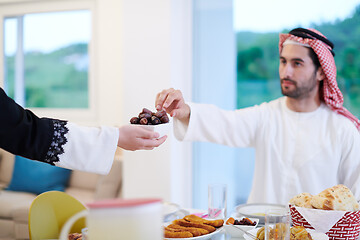 Image showing Muslim family having Iftar dinner eating dates to break feast