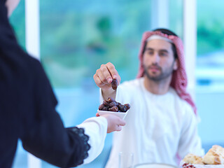Image showing Muslim family having Iftar dinner eating dates to break feast