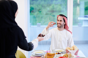 Image showing Muslim family having Iftar dinner eating dates to break feast