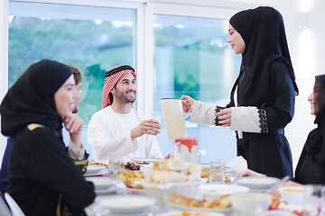 Image showing Muslim family having Iftar dinner drinking water to break feast