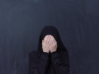 Image showing muslim woman making traditional prayer to God in front of black 