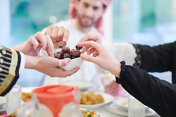 Image showing Muslim family having Iftar dinner eating dates to break feast