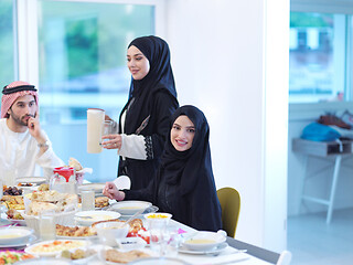 Image showing Muslim family having Iftar dinner drinking water to break feast