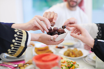 Image showing Muslim family having Iftar dinner eating dates to break feast