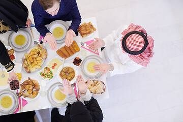 Image showing traditional muslim family praying before iftar dinner top view