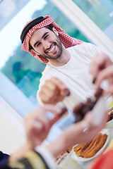 Image showing Muslim family having Iftar dinner eating dates to break feast