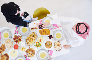 Image showing Muslim family having Iftar dinner eating dates to break feast to