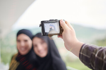 Image showing a man takes a photo of muslim women with a camera