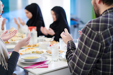 Image showing traditional muslim family praying before iftar dinner