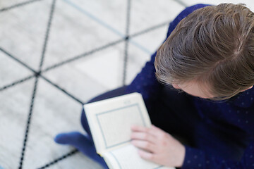 Image showing young muslim man reading Quran at home