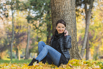 Image showing Woman with a Mobile in a Forest in the Autumn