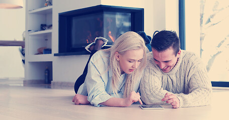 Image showing Young Couple using digital tablet on the floor