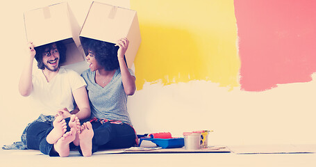 Image showing young multiethnic couple playing with cardboard boxes