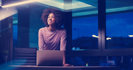 Image showing black businesswoman using a laptop in night startup office