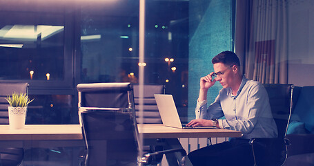 Image showing man working on laptop in dark office