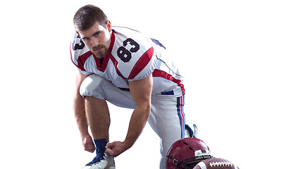 Image showing American Football Player tie his shoe laces isolated on white