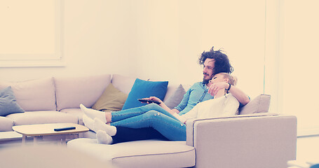 Image showing Young couple on the sofa watching television