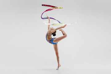 Image showing The portrait of beautiful young brunette woman gymnast training calilisthenics exercise with ribbon