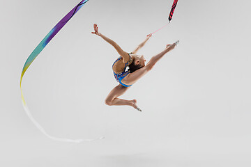 Image showing The portrait of beautiful young brunette woman gymnast training calilisthenics exercise with ribbon