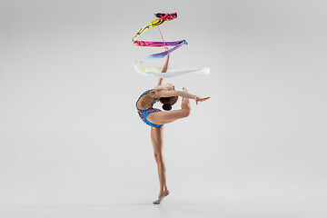 Image showing The portrait of beautiful young brunette woman gymnast training calilisthenics exercise with ribbon