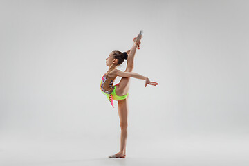 Image showing The teenager girl doing gymnastics exercises isolated on white background