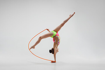 Image showing The teenager girl doing gymnastics exercises isolated on white background