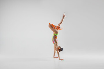 Image showing The teenager girl doing gymnastics exercises isolated on white background