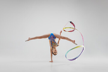 Image showing The portrait of beautiful young brunette woman gymnast training calilisthenics exercise with ribbon