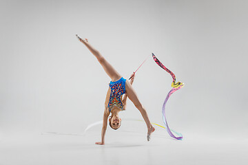 Image showing The portrait of beautiful young brunette woman gymnast training calilisthenics exercise with ribbon