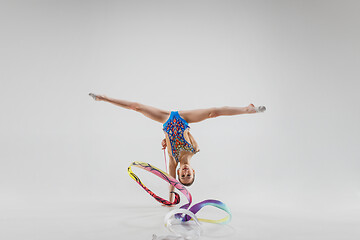 Image showing The portrait of beautiful young brunette woman gymnast training calilisthenics exercise with ribbon