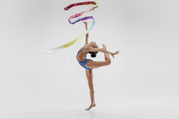 Image showing The portrait of beautiful young brunette woman gymnast training calilisthenics exercise with ribbon