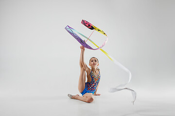 Image showing The portrait of beautiful young brunette woman gymnast training calilisthenics exercise with ribbon